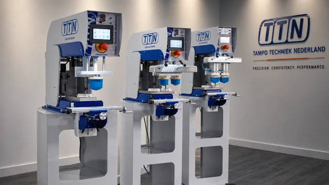 Three TTN Universal Series pad printing machines, including single-color and multi-color models, displayed in a modern showroom, representing precision and performance from Automark.